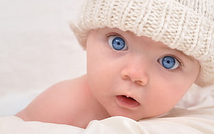 baby wearing white knit cap facing camera HD wallpaper